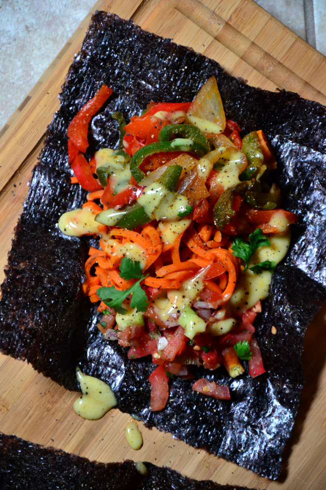 These Grain-Free Easy Fajitas are loaded with tender onions, sweet bell peppers and salsa with a curry sauce on a lovely cutting board.