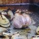 Roasted garlic hot out of the oven in a large roasting pan.